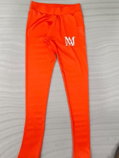 Orange athletic leggings with white "M" logo