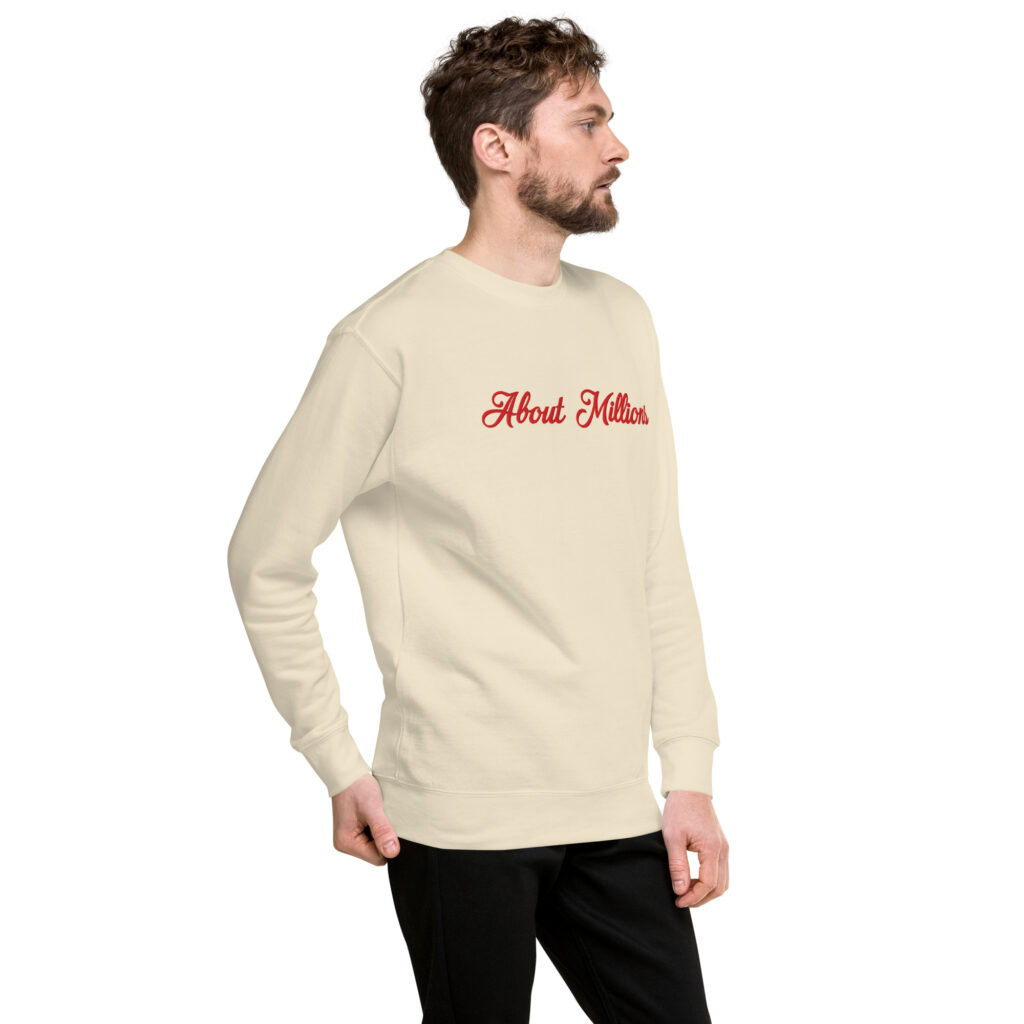 Man wearing cream sweatshirt with red script