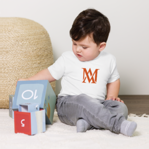 Toddler wearing monogrammed shirt plays with blocks
