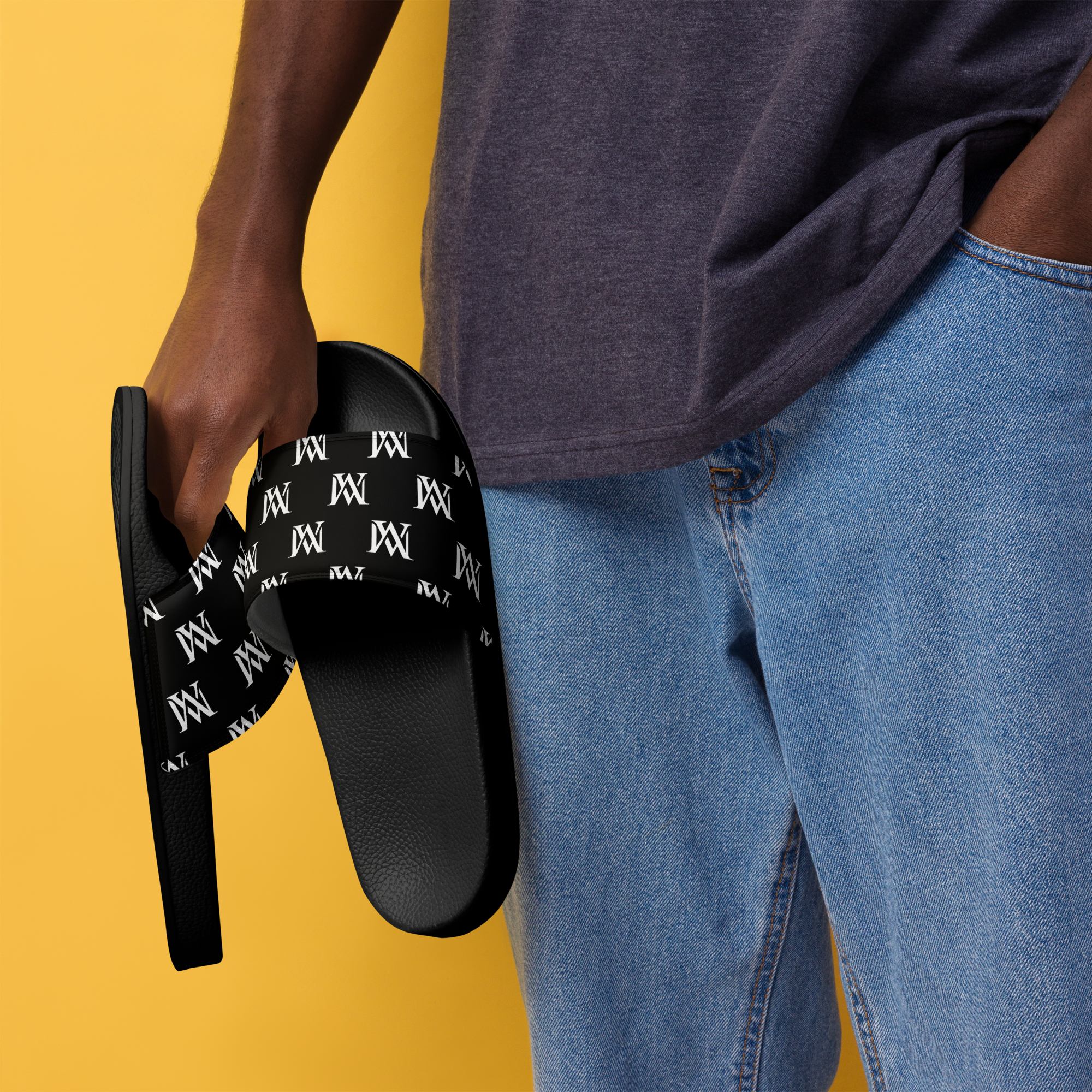 Hand holding black patterned slide sandals