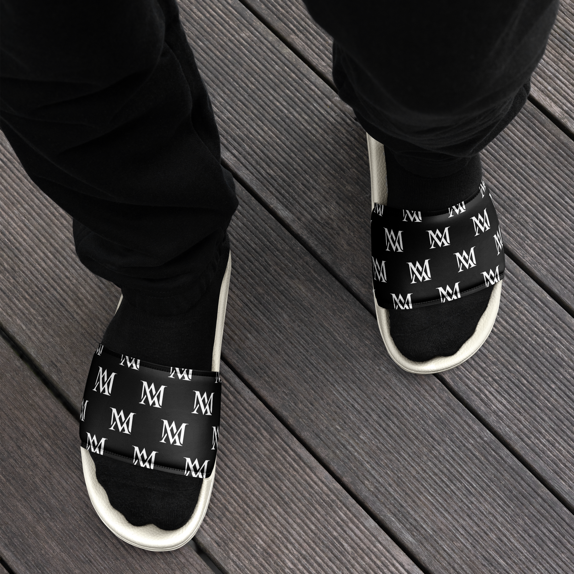 Black logo slide sandals on wooden deck