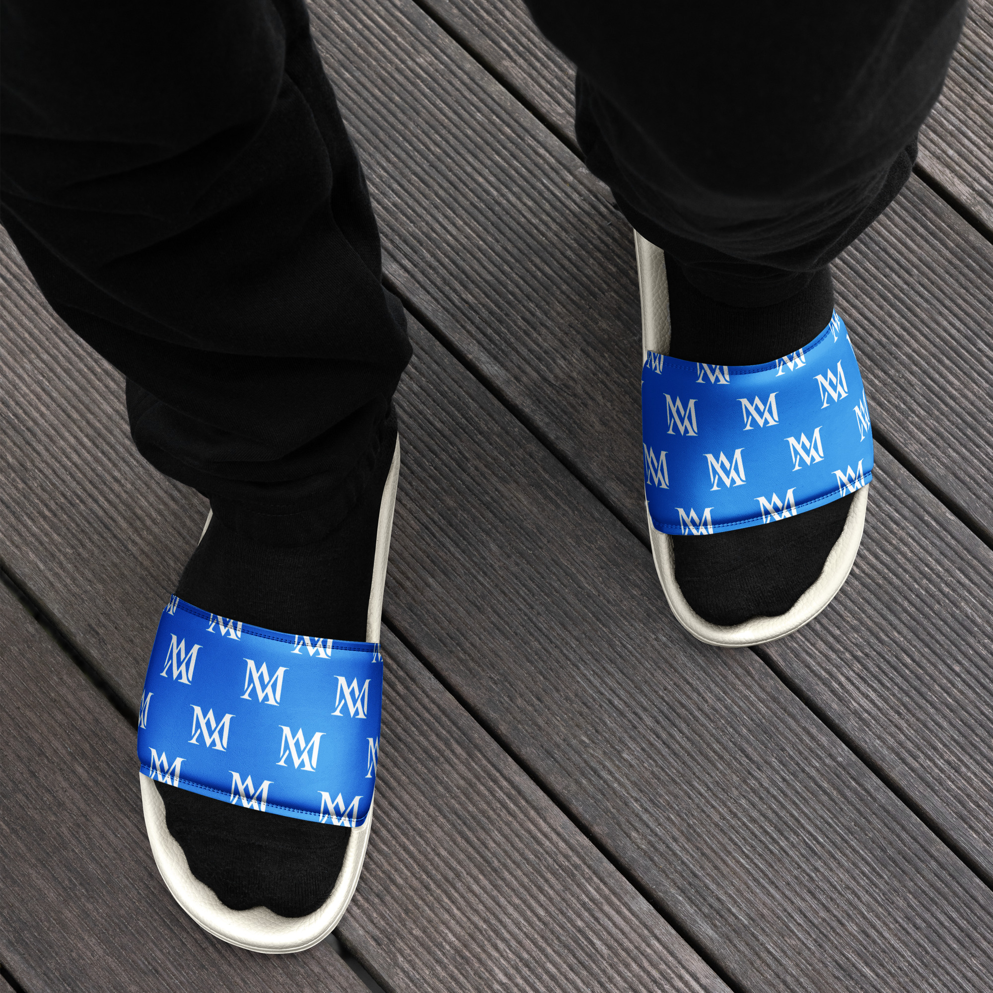 Person wearing blue monogram slides and black socks